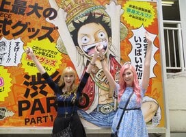 People posing in front of a poster in Japan