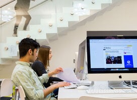 Two students sit at desktop computers
