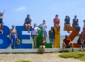 people around a Belize Sign