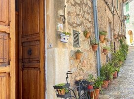 A quaint alleyway featuring a vintage bicycle leaning against a weathered door, capturing the essence of Spain and RVF International’s teach abroad adventure.