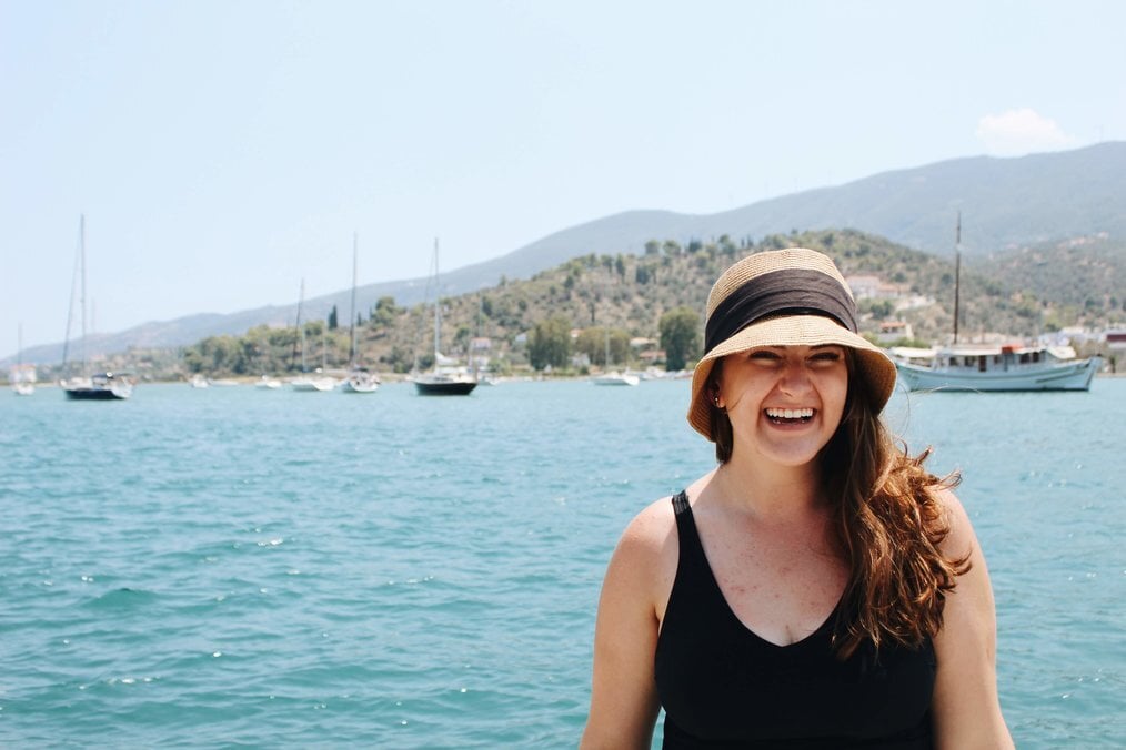 A person posing in front of a Greek island