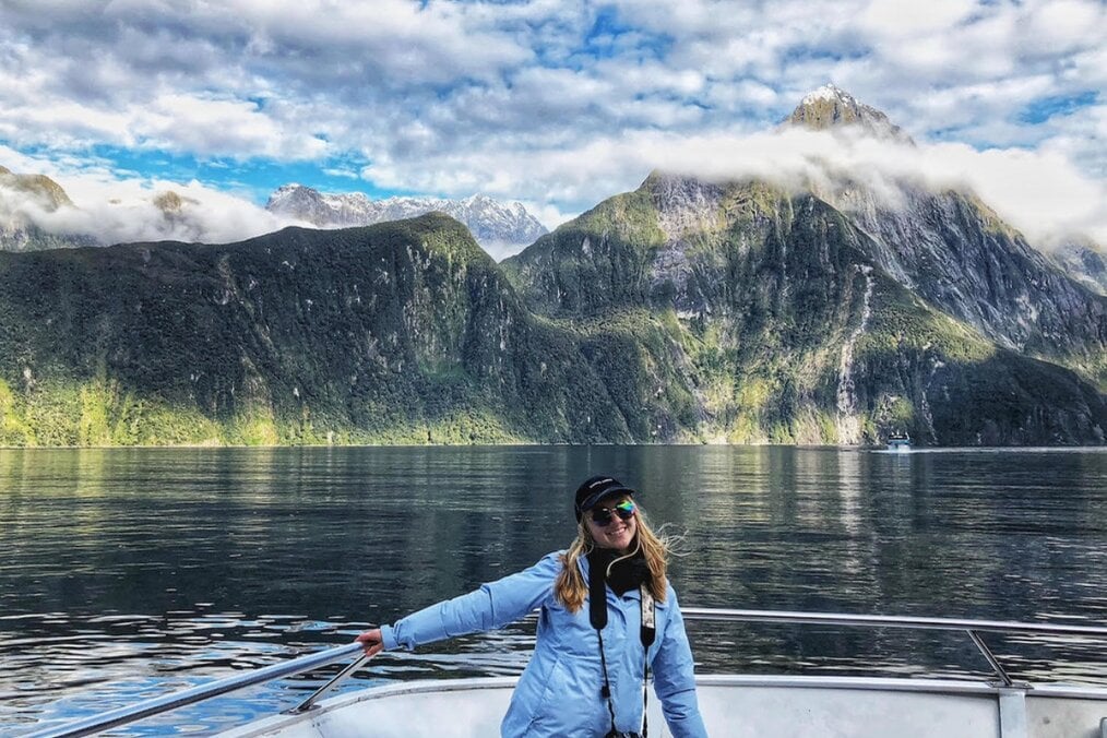 A person posing on a lake near a mountain