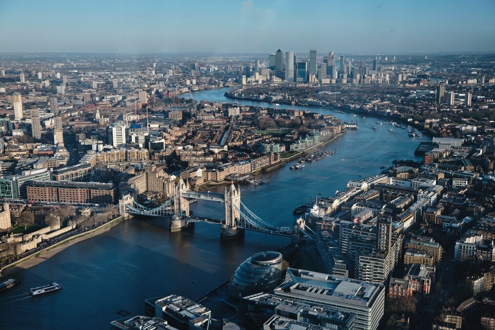 An aerial view of the city of London with buildings and a river.