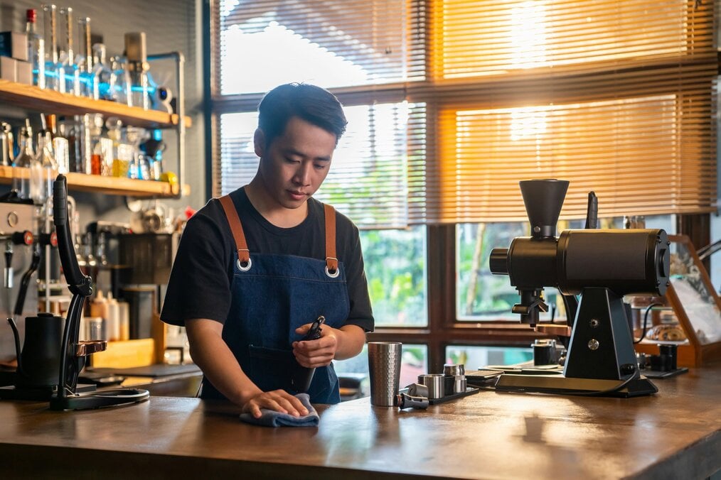A man works behind a counter at a cafe.