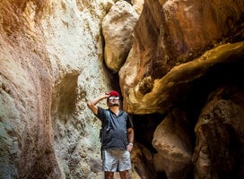 Hiking man taking his cap with his hand in a rocky cave in the province of Puntarenas in Costa Rica