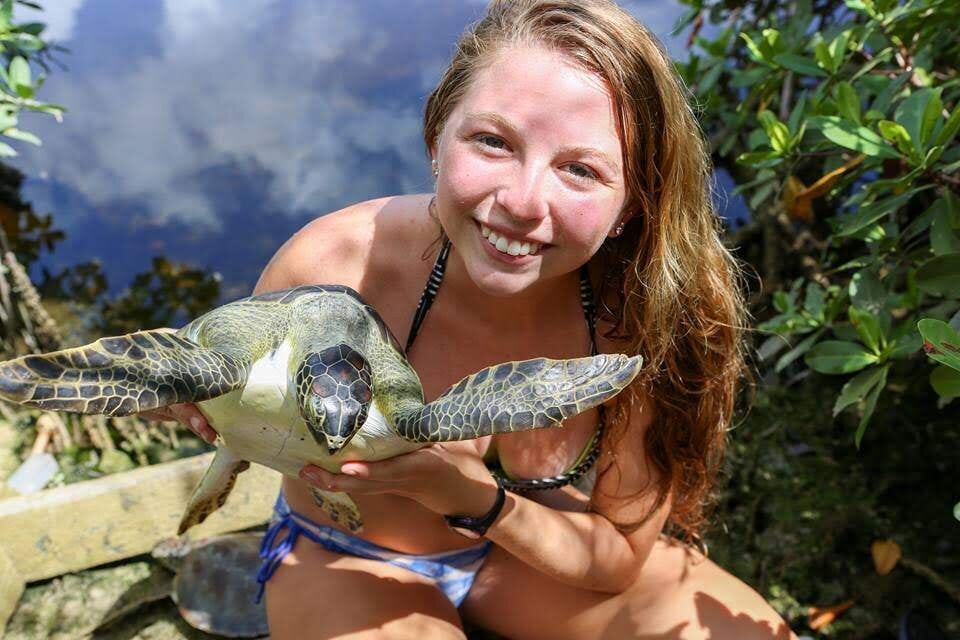 Girl holding sea turtle and smiling