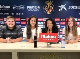 Marketing interns sit at a table with logos behind them