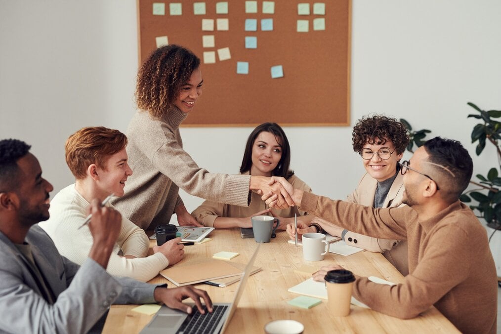 Two people shake hands at a business meeting.