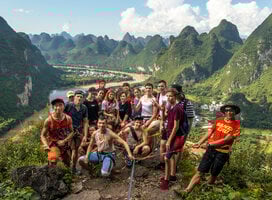 A group photos of students backdropped by Yangshuo landscape