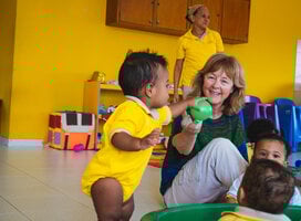 Toddler and senior volunteer playing with a ball