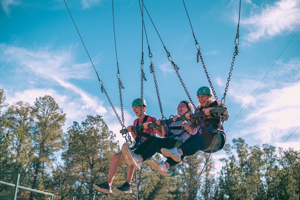 Kids sitting on a bungee swing at summer camp