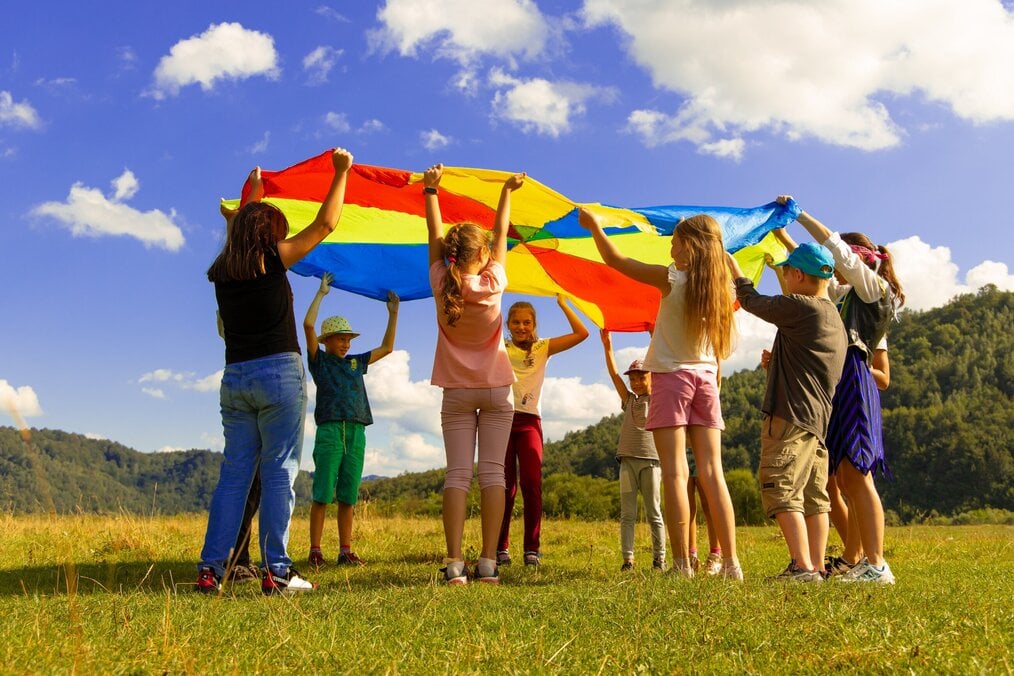Kids playing on grass in circle at summer camp