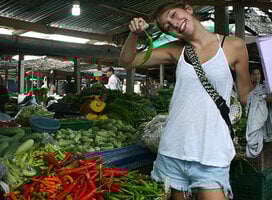 a teacher poses with a chili in a thailand market
