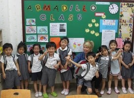 group of children in uniforms in front of board