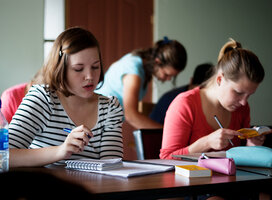 students sitting at a desk reading