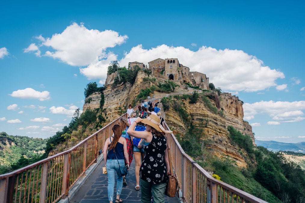 A group of people walking uphill to a castle