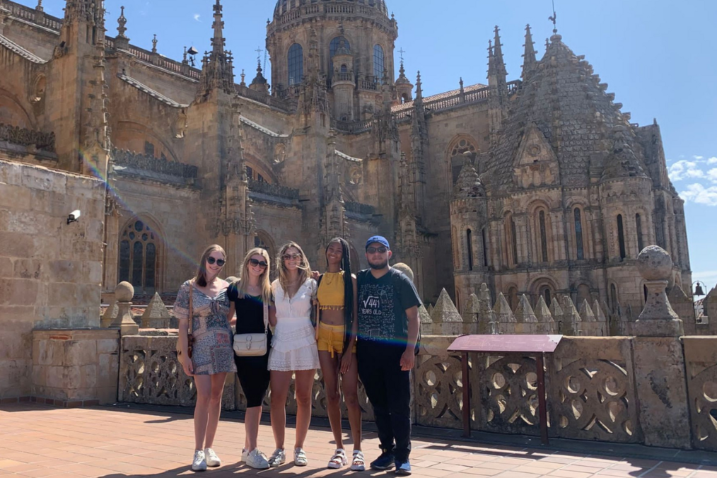 Students smiling in front of a castle