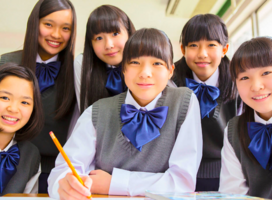 group of students wearing school uniforms with blue bows